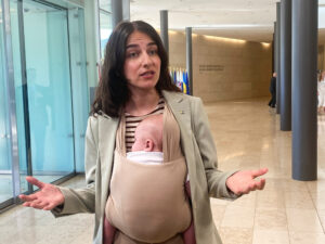 Swedish Environment Minister Romina Pourmokhtari, carrying her baby Adam, speaks to journalists before a meeting of EU environment and climate ministers, in Luxembourg